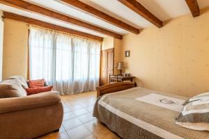 フロラックにあるGîte Chez Monique 4/7 personnes à Floracのベッドとソファと窓のある寝室 +20枚の写真