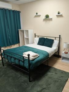 a bedroom with a bed with green sheets and pillows at Allen's property in Birmingham