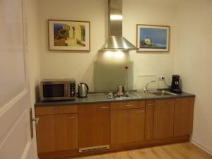 a kitchen with a sink and a microwave at Lessing-Apartment in Düsseldorf