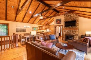 a living room with leather furniture and a stone fireplace at Peace of Mind at Hound Ears in Valle Crucis