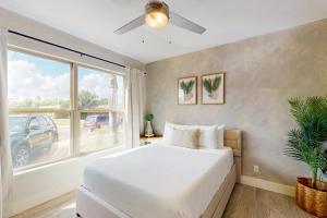 a bedroom with a white bed and a window at Casa Sol Y Mar in Port Isabel +27 photos