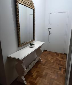 a bathroom with a sink and a mirror on the wall at Apto Clássico, Centro de Friburgo, em frente à Pça Getúlio Vargas e pertinho do Teleférico e da Pça Suspiro - Muito bem equipado - Aquecedor in Nova Friburgo