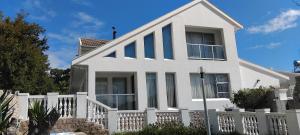 a white house with a white fence at Solomon's Nest in Glencairn +3 photos