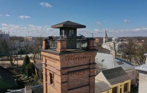 een bakstenen toren met een balkon bovenop een gebouw bij Crown Apartment Park View in Ukmergė