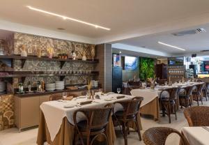 a restaurant with tables and chairs and a bar at Atlântico Praia Hotel in João Pessoa