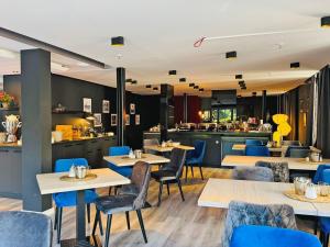 a restaurant with tables and chairs and a kitchen at DORMERO Hotel Schwäbisch Hall in Schwäbisch Hall