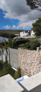 a stone wall with a house in the background at Solomon's Nest in Glencairn