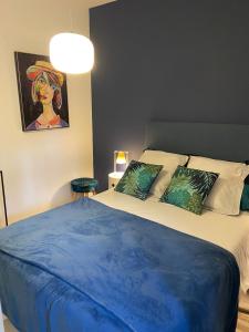 a bedroom with a bed with a blue blanket on it at Le gîte de Marina in Rignac - Aveyron