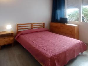 a bedroom with a bed with a red blanket and a window at Easystay Costa del Silencio Wifi in Costa Del Silencio