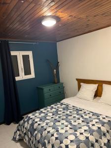 a bedroom with a bed and a blue wall at Kaz Dada in Salazie
