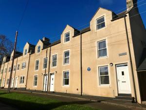 - un grand bâtiment en briques avec des portes et des fenêtres blanches dans l'établissement 3 Bed in Bamburgh 76672, à Belford