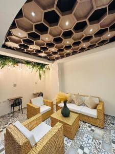 a living room with wicker furniture and a coffered ceiling at Hotel Las Americas Confort in Estación El Salto