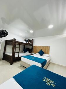 two beds in a room with blue sheets at Hotel Las Americas Confort in Estación El Salto +5 photos