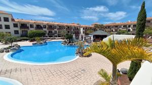 ein Innenhof mit einem Swimmingpool vor einem Gebäude in der Unterkunft Casa Marley – Balcòn Del Mar in Costa Del Silencio