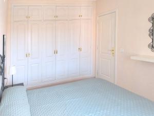 ein Schlafzimmer mit weißen Schränken und einem blauen Bett in der Unterkunft Casa Marley – Balcòn Del Mar in Costa Del Silencio + 6 Fotos