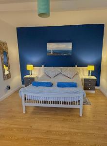 ein Schlafzimmer mit einem weißen Bett mit blauen Wänden in der Unterkunft Riverbank Apartment in Derry Londonderry