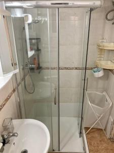 a shower with a glass door next to a sink at AlquilerSalou Loft B in Salou