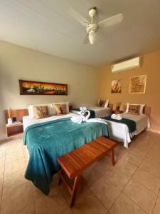 a bedroom with two beds and a bench in it at Apt Flat 225 Condomínio Pedra do Rodeadouro in Bonito +51 photos