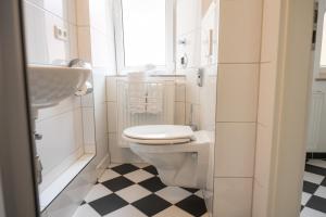 a white bathroom with a toilet and a sink at Kaisercity Apartment 5 in Nürnberg +17 photos