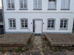 a white house with a white door at Stadtnah an der Förde 5501 in Flensburg