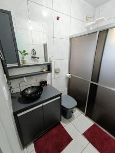 a bathroom with a black sink and a toilet at Casa Completa em Foz do Iguaçu in Foz do Iguaçu