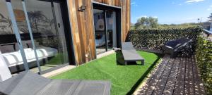 Dormir à Pinarello Villa 9 pers Piscine chauffée 5 min Plage في سانت لوسي دي بورتو فيشيو: فناء مع مقعد وكرسي على العشب