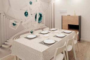 a white dining room with a table and white chairs at Las Américas Seafront - Free Wi-fi in Costa de Adeje