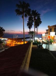 a view of a beach at night with palm trees at Las Américas Seafront - Free Wi-fi in Costa de Adeje