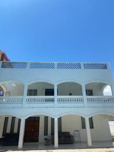 um grande edifício branco com uma grande varanda em Upendocozy villa em Praia de Diani