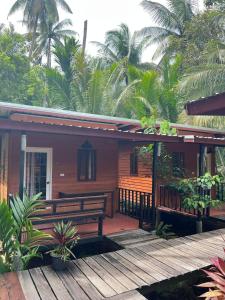 にあるKoh Libong Maldives Homestayのポーチと木製デッキのある木造住宅