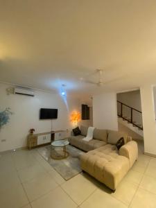 uma sala de estar com um sofá e uma TV de tela plana em Upendocozy villa em Praia de Diani