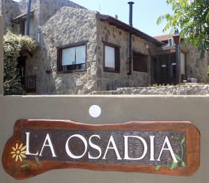 a sign that says la occidental in front of a house at La Osadia Cabañas y Suites Solo Adultos in Mina Clavero