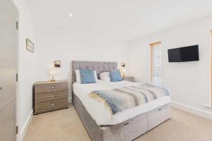 een slaapkamer met een bed en een tv aan de muur bij Host & Stay - Becalmed in Amble