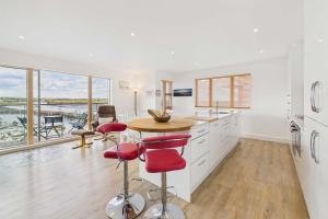 een keuken met witte kasten en een tafel met rode stoelen bij Host & Stay - Becalmed in Amble