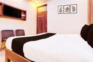 a bedroom with a bed and a flat screen tv at Hotel O Blue Stone Near Singapore Mall Lucknow in Gomti Nagar