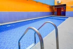 an empty swimming pool with two metal hand rails at Townhouse Oak Serenity Beach Vanur in Kuilapayam