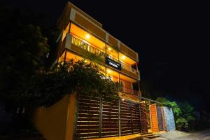 a tall building with lights on it at night at Townhouse Oak Serenity Beach Vanur in Kuilapayam +20 photos