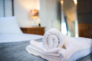 a pile of towels sitting on top of a bed at Stylish Studio in the Heart of Stamford Perfect Location in Stamford +22 photos