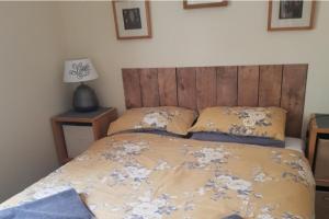 une chambre avec un lit avec une tête de lit en bois dans l'établissement 3 Bed Villa Sleeps 5 - Hot Tub Pool Parking, à Château-Garnier