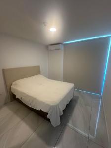 a small bed in a room with a blue light at Altamira Surubi-i in Estancia Sarubi