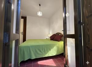 a bedroom with a bed with a green bedspread at 8 ARBOUSIERS VILLA 19 in Bonifacio +8 photos