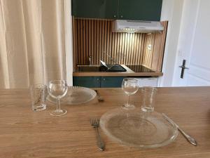 un tavolo di legno con due piatti e bicchieri sopra di Appartement à Manosque - Centre Historique a Manosque