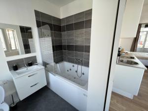列万La Suite Balneo 2p - centre ville的带浴缸和水槽的白色浴室