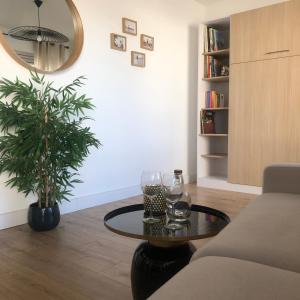 Una sala de estar con una mesa de café y una planta. en STUDIO 38 m2 Point Zéro, en La Grande-Motte