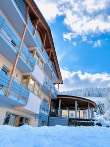 a building with snow in front of it at Residence La Moretina in Commezzadura