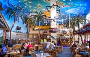 a restaurant with a mural of palm trees on the ceiling at Beach and Downtown Hollywood in Hollywood