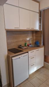 Una pequeña cocina con gabinetes blancos y un fregadero. en Simpi, en Pržno