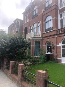 a brick building with a fence in front of it at Flora's Palace - The Hague Scheveningen in The Hague +41 photos