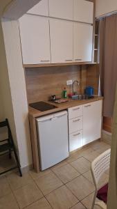 Una pequeña cocina con gabinetes blancos y un fregadero. en Simpi, en Pržno