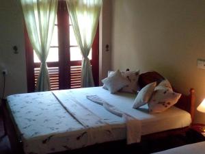 a bedroom with a large bed with a window at Mimosha holiday inn in Godapola